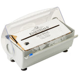 A white plastic Rapid Wrap Film Dispenser holds a roll of Kitchen Essentials film wrap. The box has a transparent hinged lid partially open, exposing the film wrap and a serrated edge for cutting. Four black rubber feet keep this dispenser steady.
