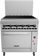 A commercial stainless steel Vulcan restaurant range with six black control knobs, a black grill top, an oven below, caster wheels, and a red power switch. The surface has a backsplash and the Vulcan logo is visible on the front panel.