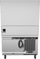 The image shows the back of a large silver appliance with a vented panel, coiled power cord, drainage pipe, and black caster wheels—typical features of a refrigerated base often used beneath a restaurant range or charbroiler.