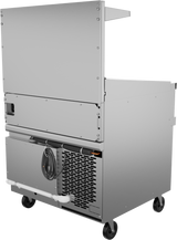 A commercial stainless steel kitchen appliance on wheels, featuring a vented lower section and refrigerated base, with a power cord wrapped on hooks, white drainage pipe below, and large metal upper panel; shown from an angle revealing the back and side.