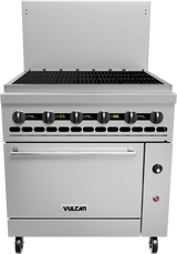 A commercial stainless steel restaurant range with six black control knobs, a large flat cooking surface with grates like a charbroiler, oven below, right-side control panel, and four caster wheels. The Vulcan logo is visible on the front.