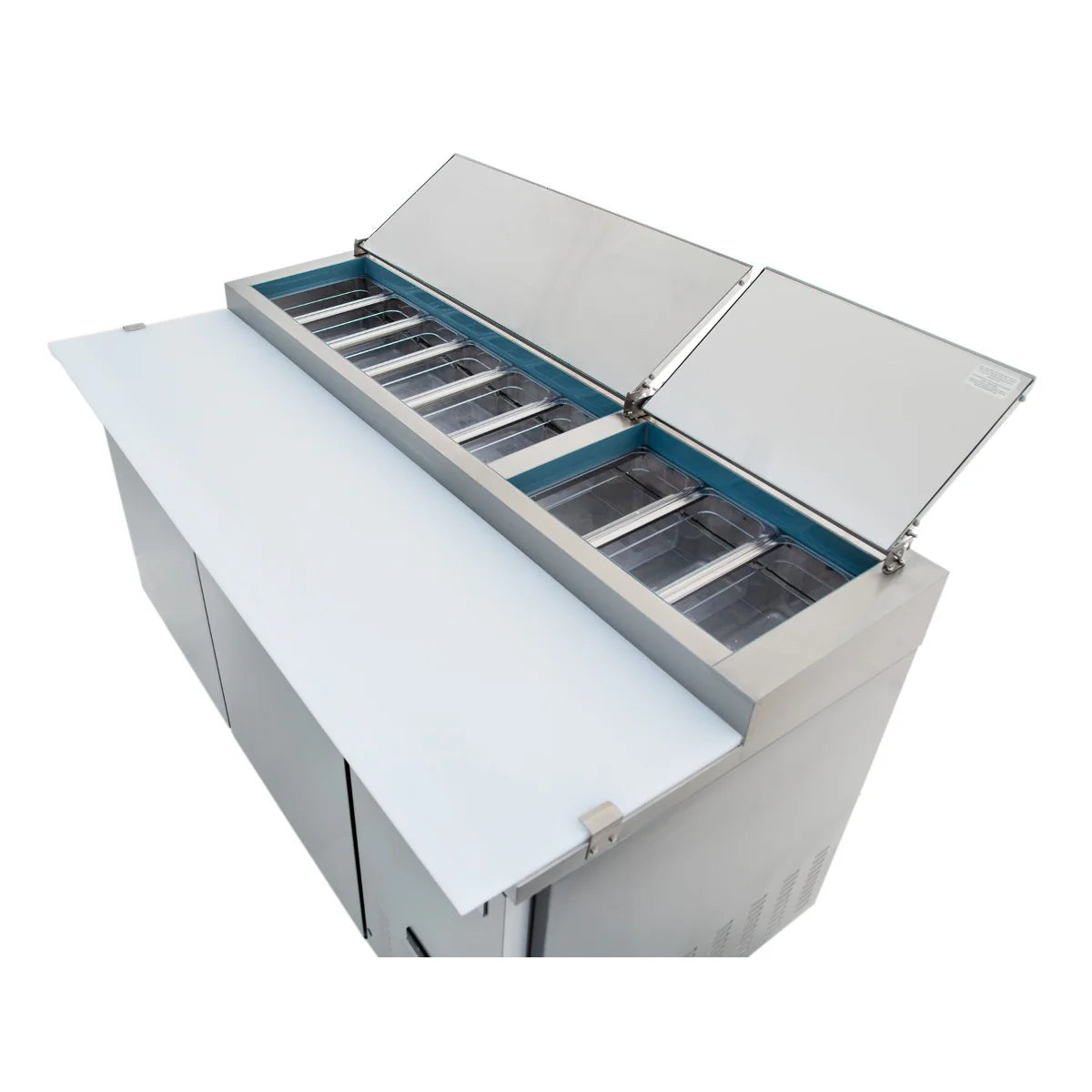A commercial Empura Refrigeration pizza prep table features stainless steel construction, two open hinged lids revealing empty ingredient trays, a large white cutting board in front, and storage cabinets below.