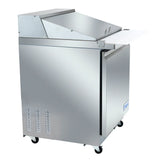 This Empura refrigeration mega top prep table features a commercial stainless steel build with a closed, angled lid, front door, lower vent holes, and four casters. Its white cutting board extends from the front for efficient sandwich prep.
