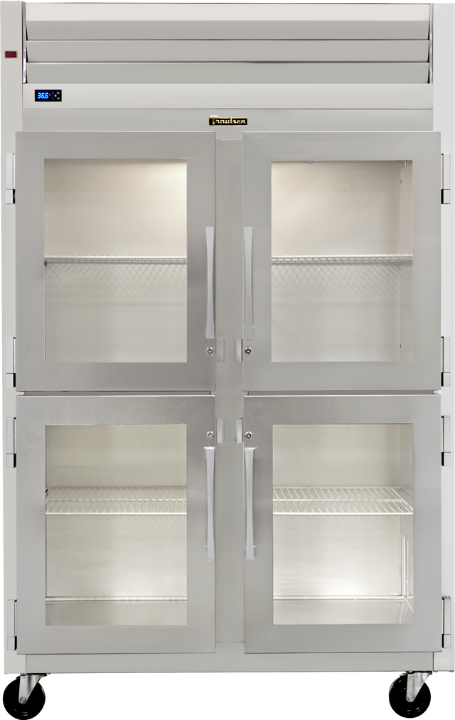A large Traulsen commercial stainless steel reach-in refrigerator with four glass doors, metal handles, and visible wire shelves inside. The unit includes wheels, top ventilation, and a digital temperature display on the upper left.