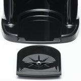 A close-up of a black plastic beverage dispenser base with a curved, detachable drip tray in front. The drip tray features a raised star-shaped pattern and central hole, designed to catch spills from the insulated appliance above. The surface is shiny and reflective.