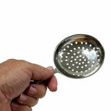 A hand holds a round, stainless steel Julep Strainer with multiple holes. The spoon is angled upward, showing its perforated bowl and firm grip against a plain white background. This strainer is also dishwasher safe for easy cleaning.