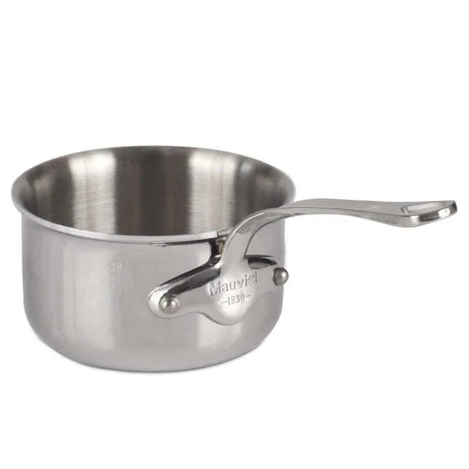 A small Mauviel M'Cook Sauce Pan with a long, sturdy handle and a shiny stainless steel finish. The oven safe sauce pan features a riveted handle engraved with “Mauviel 1830” and is set against a plain white background.