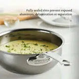 A Hestan Nanobond Saucier pan, 2.0qt, filled with creamy soup and garnished with chopped herbs sits on a white countertop. The text above reads: "Fully sealed rims prevent exposed aluminum, delamination or separation.