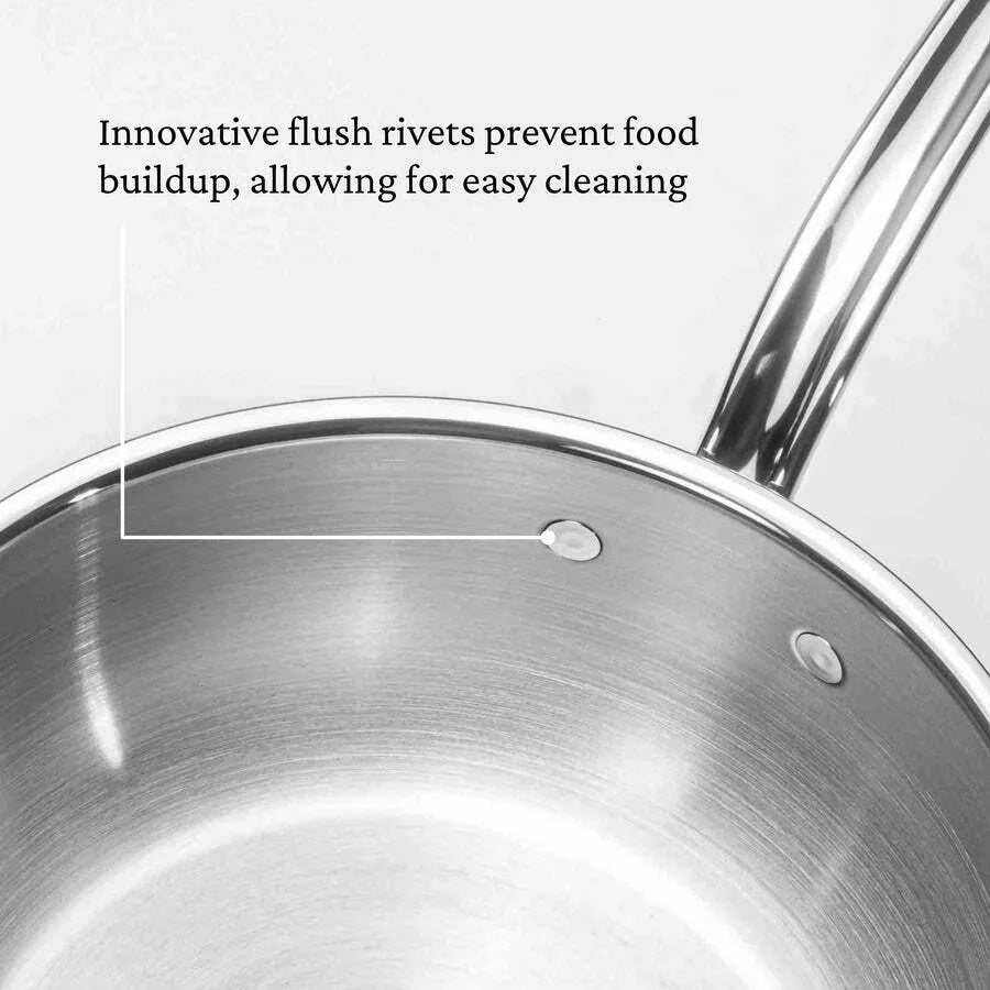 A close-up of a Hestan Probond Essential pan, 28cm/5.0qt, shows smooth, flat rivets inside. Text overlays read: Innovative flush rivets prevent food buildup, allowing for easy cleaning. The pot’s handle is partially visible.