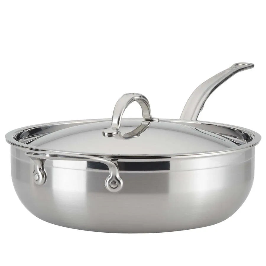 A shiny 28cm stainless steel sauté pan, like the Hestan Probond Essential pan, with a matching domed lid and long curved handle. The wide, flat bottom holds up to 5.0qt, and sturdy metal rivets secure the handle to the body. The lid features a loop handle.