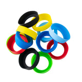 A pile of colorful silicone wristbands, resembling Widemouth Sauce Bands, is scattered on a white background. The black, yellow, blue, red, and green bands overlap in a loose circular arrangement.