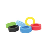 Six colorful silicone rings are arranged on a white background. The rings, perfect as Widemouth Sauce Bands for squeeze bottles, come in green, black, two shades of blue, red, and yellow. Most lie flat while the yellow ring stands upright with a smooth texture.