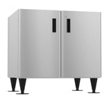 A stainless steel double-door equipment stand with black vertical handles and tapered legs. The smooth, reflective surface and modern industrial design make it ideal for kitchens or utility areas, perfect for supporting icemaker dispensers.