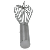 A stainless steel French Whip with a cylindrical handle stands upright. The brand TABLECRAFT is engraved on the handle. Multiple wire loops form a balloon shape, perfect for mixing or beating ingredients, and it's dishwasher safe for easy cleanup.