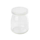 A small, clear, empty glass jar with a wide mouth and a flat, round, transparent lid. The single-serve jar has smooth sides, sits on a white background, and is dishwasher safe. The lid fits snugly on top of the jar.