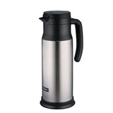 A stainless steel beverage server thermal carafe with a black handle, black spout, and lid. The cylindrical carafe features vacuum insulation, a small rectangular brand label near the base, and a smooth, reflective surface with a matte black plastic base.