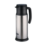 A stainless steel beverage server thermal carafe with a black handle, black spout, and lid. The cylindrical carafe features vacuum insulation, a small rectangular brand label near the base, and a smooth, reflective surface with a matte black plastic base.