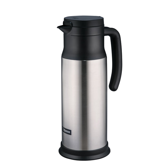 A stainless steel beverage server thermal carafe with a black handle, black spout, and lid. The cylindrical carafe features vacuum insulation, a small rectangular brand label near the base, and a smooth, reflective surface with a matte black plastic base.