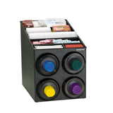 A black NSF cup dispensing cabinet holds cups, lids, stirrers, sugar packets, and drink accessories. Four round cup dispensers with colored rings sit on the front, while compartments on top organize packets and stackable cups and lids.