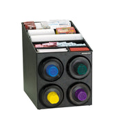 A black NSF cup dispensing cabinet holds cups, lids, stirrers, sugar packets, and drink accessories. Four round cup dispensers with colored rings sit on the front, while compartments on top organize packets and stackable cups and lids.