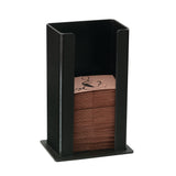 A black polystyrene vertical napkin dispenser holds a stack of brown paper napkins with a decorative black swirl design on top. The dispenser, similar to a Coffee Sleeve Dispenser, is open at the top and front for easy access.