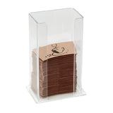 A clear polystyrene dispenser holds a neat stack of brown paper napkins with a black ampersand and coffee steam design. The dispenser has an open front for easy, spring-loaded access to the napkins.