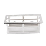 A stainless steel taco holder with two rows, each featuring three curved slots to keep tacos upright. The open rectangular frame boasts a minimal, polished metallic finish and is pictured against a plain white background.