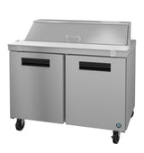 A Hoshizaki Sandwich Top Refrigerator with two stainless steel doors, black handles, and four wheels. Its raised lid is perfect for food storage in a prep station, showcasing a clean, industrial design with a brushed metal finish.