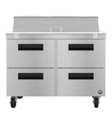 A stainless steel commercial kitchen prep table on wheels with four black-handled drawers, a flat top work surface, and a raised back panel—perfect next to your reach-in refrigerator. Features a small round logo on the lower right corner for easy brand ID.