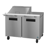 A commercial stainless steel Hoshizaki Steelheart mega top refrigerator prep table with two doors, black handles, casters, and an elevated covered section for ingredients. This unit features a flat work surface and boasts a modern, industrial appearance.