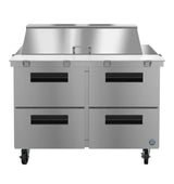 A stainless steel commercial kitchen prep table with four black-handled drawers, a raised rear backsplash, flat workspace, and caster wheels for mobility pairs perfectly with a 48" reach-in refrigerator for efficient food prep and storage.