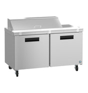 A commercial Hoshizaki Steelheart Series Sandwich Top Refrigerator features a raised, lidded ingredient compartment, two large doors below, four caster wheels for mobility, black handles, and a smooth stainless steel workspace with a small logo on the lower right corner.