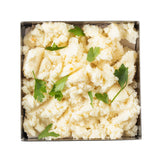 A square stainless steel bowl filled with creamy, fluffy mashed potatoes garnished with fresh parsley leaves. The slightly chunky potatoes are served in a 1-1/4 qt bowl and placed on a white background.