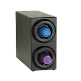 A black rectangular wine bottle holder with two circular, side-by-side compartments at the front, each holding a single capsule—one blue, one purple. Its design echoes a stackable cup dispenser, with capsules resembling Nespresso coffee pods.