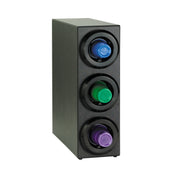 A black rectangular coffee pod holder stands upright, resembling a compact Cup Dispenser Cabinet, with three circular slots on the front—each housing a blue, green, or purple coffee pod—set against a plain white background.