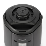 A close-up view of a black Zojirushi beverage dispenser shows its top lid with a locking mechanism and handle. The insulated stainless steel vacuum liner keeps drinks hot or cold, while a clear window displays the liquid level inside.