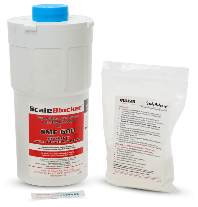 A white cylindrical SCALEBLOCKER Water Filter cartridge with a blue cap stands upright. Beside it is a clear packet for SMF systems labeled Vulcan ScaleRelease containing instructions. A small test strip with colored squares lies in front.