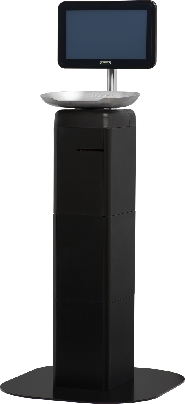 A black, rectangular self-serve kiosk with a wide base, a touchscreen monitor mounted on top, and a metallic tray below the screen—resembling the modern, minimalistic design of the Hobart FS-100 FreshServe Scale. The screen is off and blank.