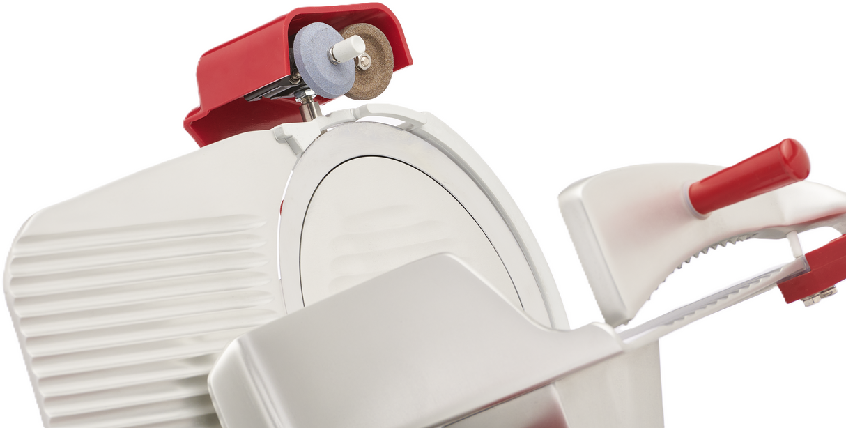 Close-up of a Berkel B10-SLC gravity feed slicer with a shiny circular blade, red handles, and built-in sharpening stone. Its metallic ribbed body highlights the clean, modern design of this commercial meat slicer.