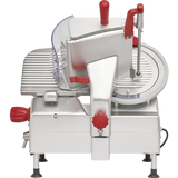 A commercial gravity feed slicer with a silver metallic body, red knobs and handles, a large 12 carbon steel knife on the right, a grooved food carriage on the left, and a transparent safety guard, standing on four small legs.