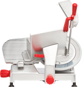 A silver and red manual gravity feed slicer with a large carbon steel knife blade, ridged sliding tray, red knobs and handles, and a safety guard, photographed from the side on a white background.