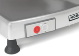 Close-up of a metallic Hobart machine with a control panel featuring a large red OFF button and a gray ON button labeled KNIFE. The Heavy Duty Meat Slicer has rounded black legs and a partial HOB brand label visible on the right.
