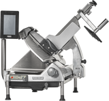 A silver Hobart heavy duty meat slicer with a digital control panel, adjustable slicing blade, black handle, removable knife, and safety guard. The automatic meat slicer is angled with a display screen on the left and stands on four short legs.