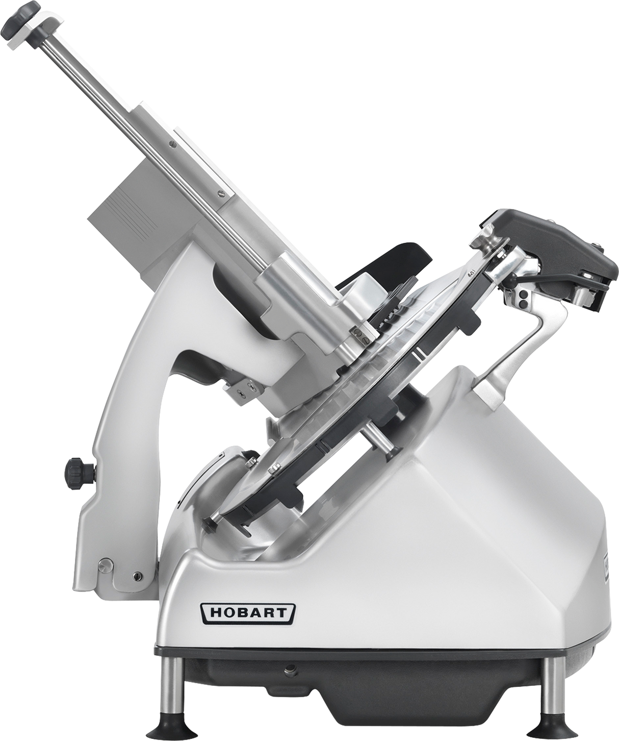 A metallic Hobart Heavy Duty Meat Slicer is shown in side view. The machine has a tilted blade, adjustable handle, and supportive base with black feet. The Hobart logo is visible on the lower front panel. The slicer is clean and modern in design.