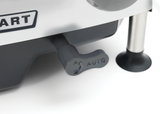 A close-up of a control lever labeled AUTO with a fish icon, attached to a Heavy Duty Meat Slicer with a CleanCut knife. A metal leg and rubber foot are visible on the right, along with part of a label reading ART on the appliance.