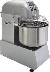A large, industrial Hobart Spiral Mixer in stainless steel features a spiral dough hook, a control panel with buttons and dials on top, a protective wire guard over its 130-pound capacity bowl, and the Hobart logo on both the sturdy base and bowl.