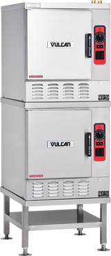 A commercial stainless steel Vulcan double-stacked convection steamer with red and black control panels on the right side of each unit, each featuring a handle, dials, and indicator lights, stands on a metal frame with four legs.