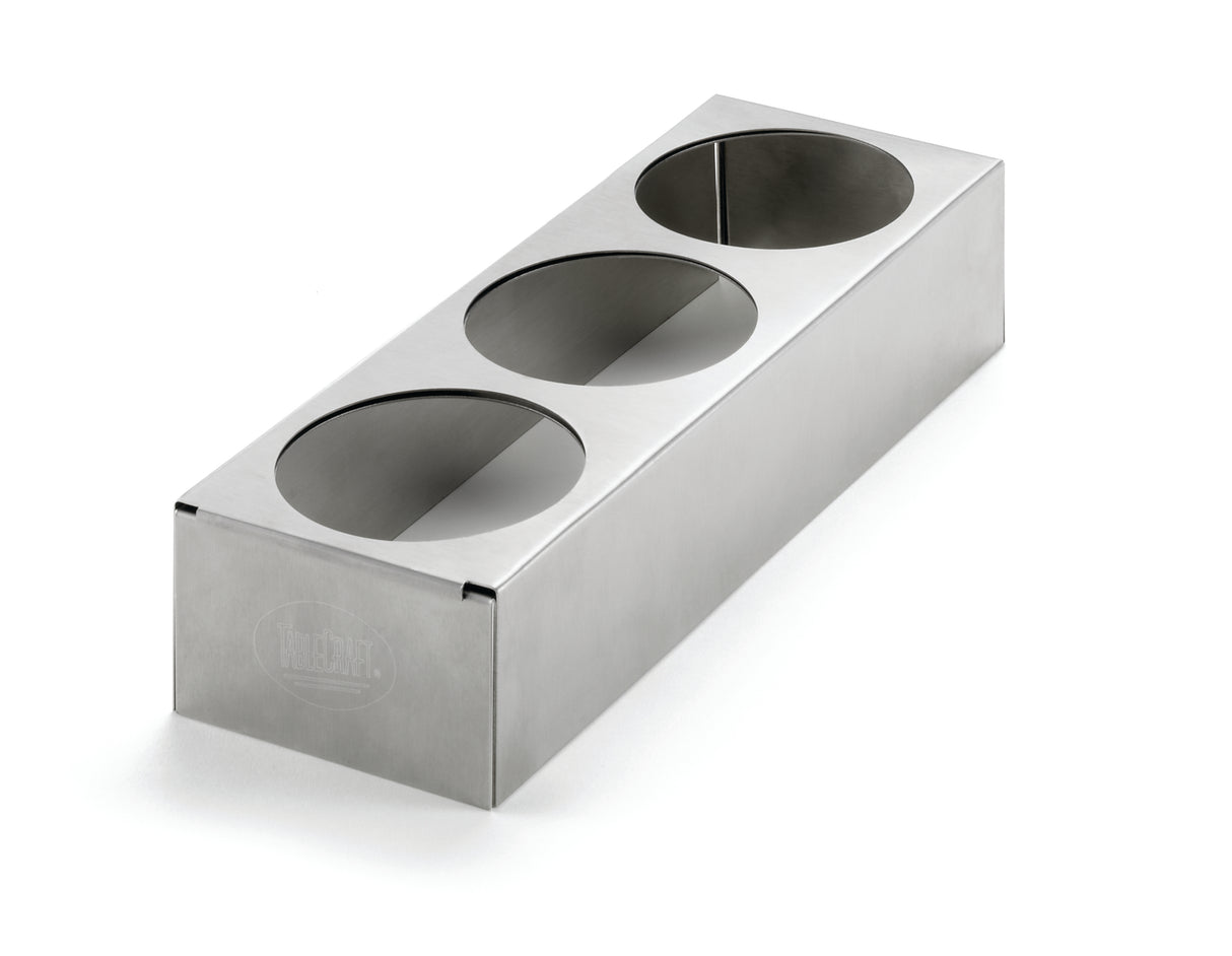 A rectangular stainless steel squeeze bottle holder with three circular cutouts on the top surface, set against a white background. The brushed finish and engraved logo on the front left side give this expandable counter-top accessory a sleek look.