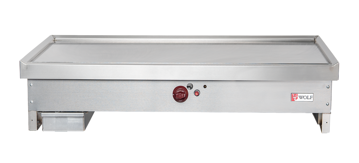 A stainless steel teppanyaki griddle with a flat cooking surface, red center control knob, indicator lights, left-side grease trap, and Wolf TYG60C_LP branding on the right. The rectangular design suits any commercial kitchen griddle setup.