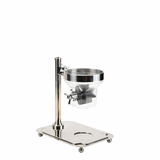 A stainless steel and clear plastic laboratory funnel apparatus with a stand and base, similar to a TableCraft cereal dispenser. The funnel is mounted on a vertical rod and features a paddle handle valve for controlled dispensing. The sturdy base ensures stability.